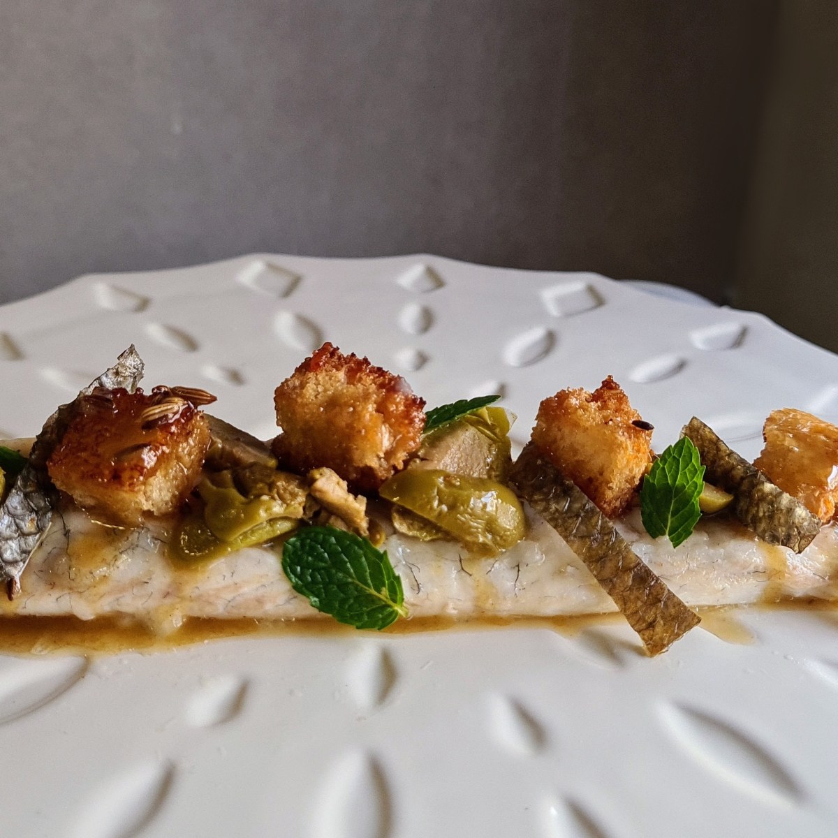 Branzino al forno con limone, olive, semi di finocchio e&nbsp;crostini