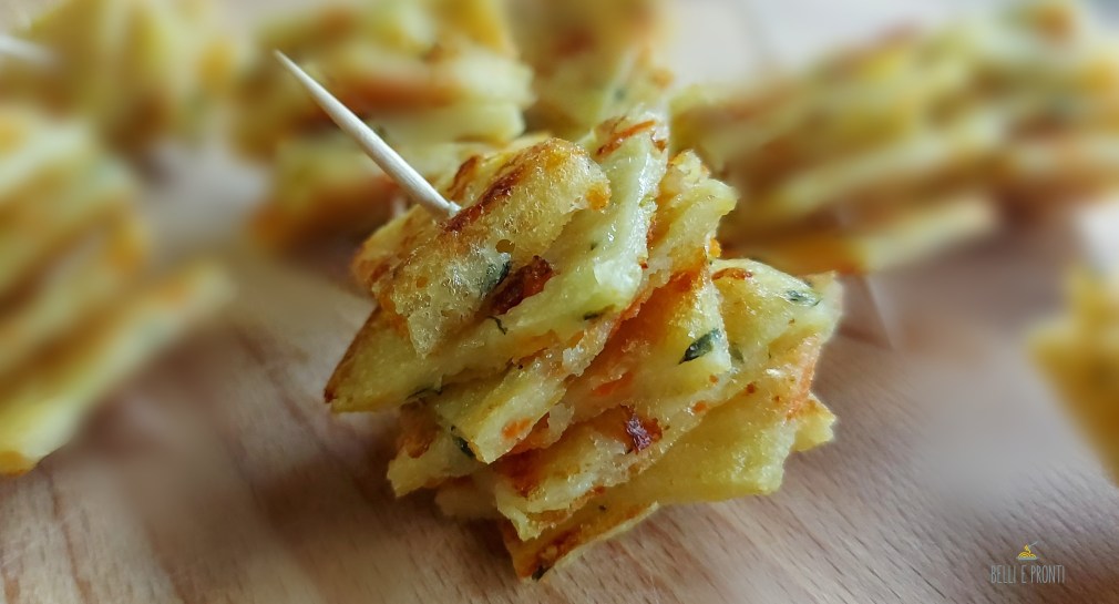 Una focaccia sottilissima tagliata a quadretti e infilata sugli stuzzicadenti pronta per essere presentata agli ospiti per un aperitivo sfizioso.