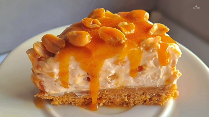 La fetta della cheesecake al caramello salato e arachidi mostra la crema di farcitura ottenuta senza aggiunta di gelatina.