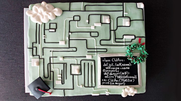 Una torta millefoglie ricoperta di pasta di zucchero con codice informatico, corona della laurea e tocco in pasta di zucchero.