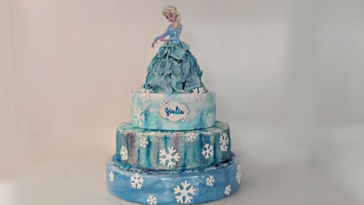 una torta a 3 piani con top cake che riproduce Elsa in 3 D