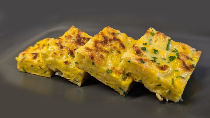Idea aperitivo: frittata di mais ed erba cipollina tagliata a cubotti.