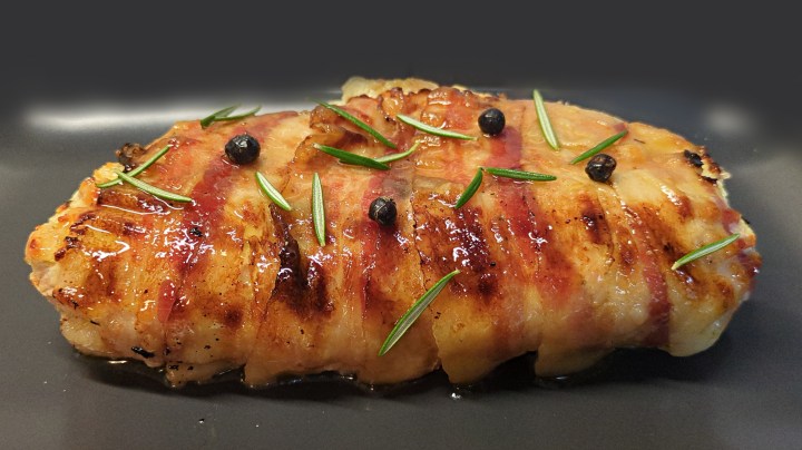 Fette sottili di petto di pollo distese sulla pancetta, farcite con ricotta speck e provola, arrotolate e cotte in forno. Decorazione con bacche di ginepro e foglioline di rosmarino fresco.