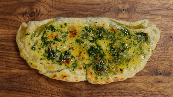 Ricetta di pane ripieno cotto in padella ispirata al gozleme turco: una sottilissima sfoglia di pane in cui proponiamo un ripieno di spinaci e provola affumicata, nappato con olio al prezzemolo. Filante e godurioso!
