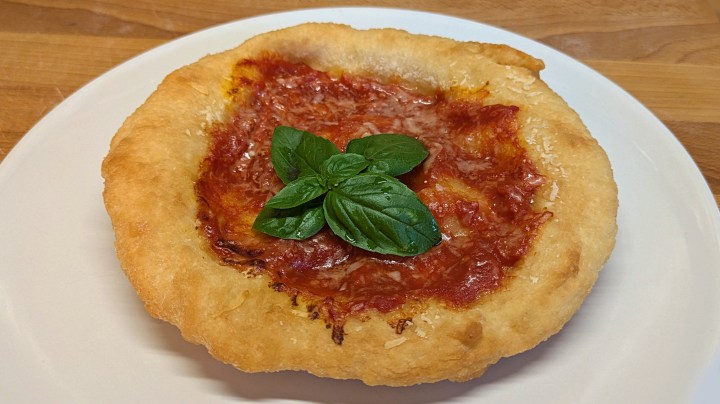 Le pizzelle fritte: impasto pizza fritto, condito con salsa di pomodoro e formaggio grattugiato e ripassato al forno. Le pizzelle fritte sono croccanti fuori e morbide dento. E non sono le montanare. Se volete sapere la differenza tra le montanare e le pizzelle, leggete l'articolo sul Bell e Pronti blog.